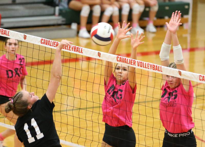 Ottawa's Bell Markey sends the ball over the net as L-P defenders Ava Currie and teammate Aubrey Duttlinger look to block it during Volley for a Cure night on Tuesday, Oct. 1, 2024 at AJ Sellett Gymnasium.