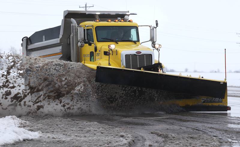A DeKalb County Highway Department snowplow removes slushy wet snow from Peace Road Tuesday, Jan. 9, 2024, in DeKalb. Snow is expected to continue throughout the day with 7 to 10 inches of snow expected.