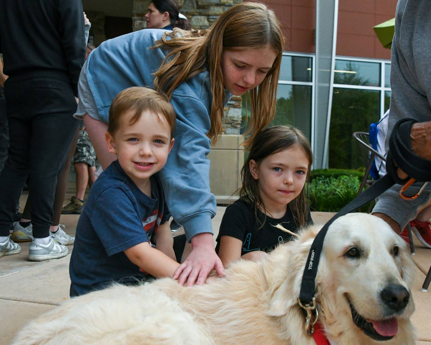 Judah Vargas, Quin Vargas and Oli Vargas of DeKalb pet Joey of Canine 4 Christ on Sunday Sept. 21, 2025, before the start of the Be the One Walk held at the Kishwaukee Health & Wellness Center in Sycamore.