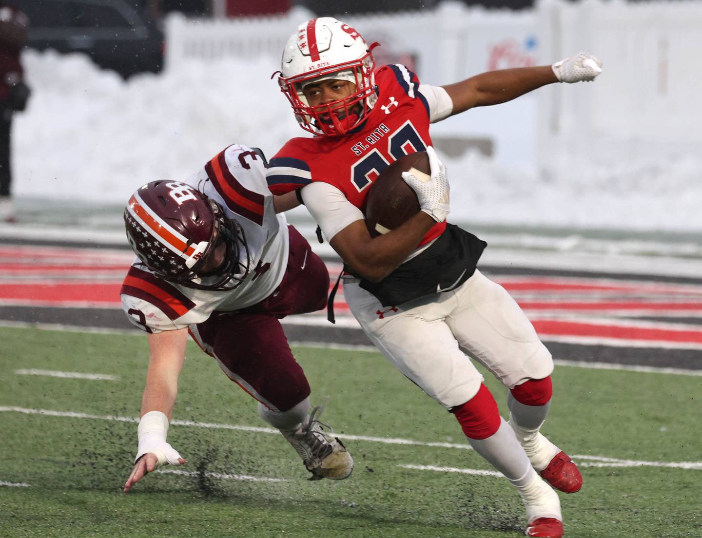 St. Rita's Damon Sutton Jr. gets by Brother Rice's Michael Fitzgerald Wednesday, Dec. 3, 2025, during their IHSA Class 7A state chamionship game in Huskie Stadium at Northern Illinois University in DeKalb.