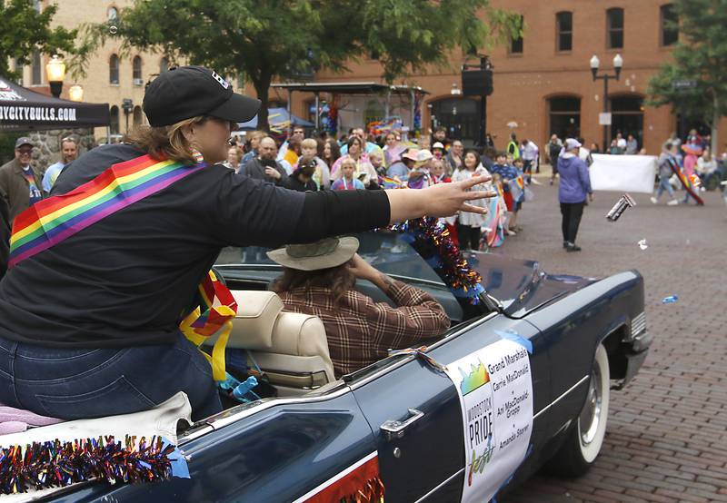 One of the three Grand Marshals of the PrideFest Parade Amanda Storer tosses candy to the crowd during the Woodstock PrideFest Parade Sunday, June 11, 2023, around the historic Woodstock Square.