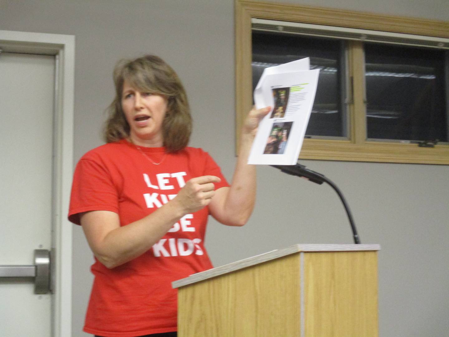 Drag show opponent Molly Krempski of Yorkville displays social media posts of drag queens at the Oct. 11, 2022 Yorkville City Council meeting.