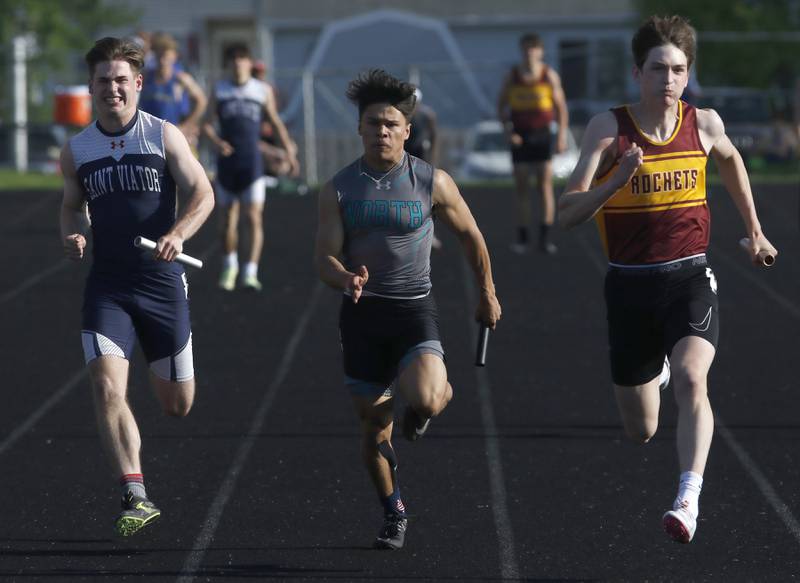 Saint Valor’s Conor Benz, Woodstock North’s Mark Duenas, and Richmond-Burton’s Sean Rockwell race to the finish line in the 4 x 100 meter relay during the IHSA Class 2A Belvidere Boys Track and Field Sectional Thursday, May 19, 2022, at Belvidere High School.