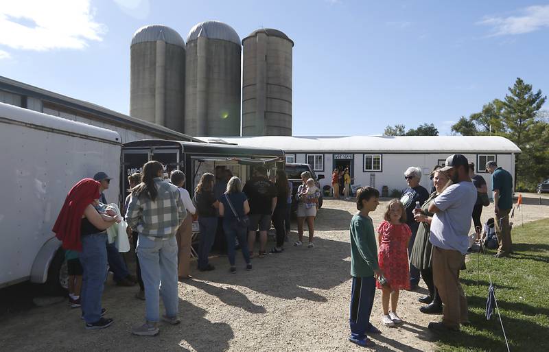 People wait in line to get food from DAMO BBQ food truck during a stop on the McHenry County Farm Stroll on Sunday, Sept. 29, 2024, at Wand Farms in Harvard. The stroll, featuring 11 McHenry County family farms, included tours, demonstrations and products for sale.