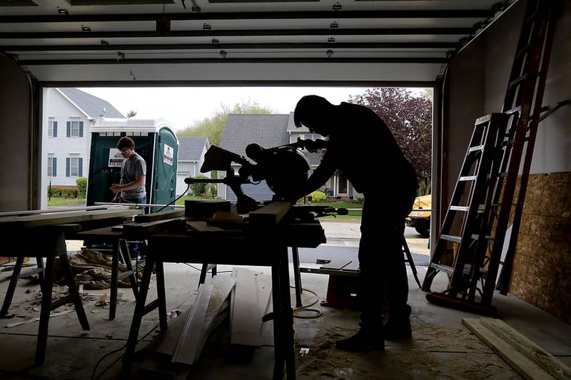 Erik Moctezuma, a senior in the Woodstock Building Trades Program, uses a chop saw as he builds stairs Monday, May 8, 2023, in the home that they are building in Woodstock. This will be the program’s 43 completed home since it began in 1972.