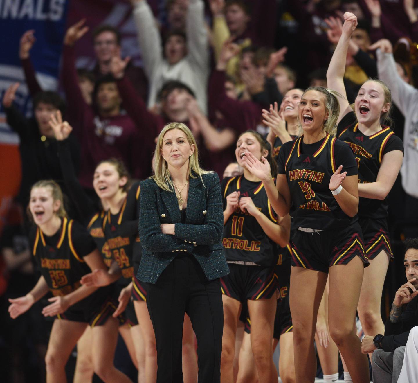 Montini players celebrate a three-pointer as head coach Shannon Spanos watches from the sideline during the first quarter of the IHSA Class 3A girls state basketball championship game at CEFCU Arena on Saturday, March 8, 2025 in Normal.