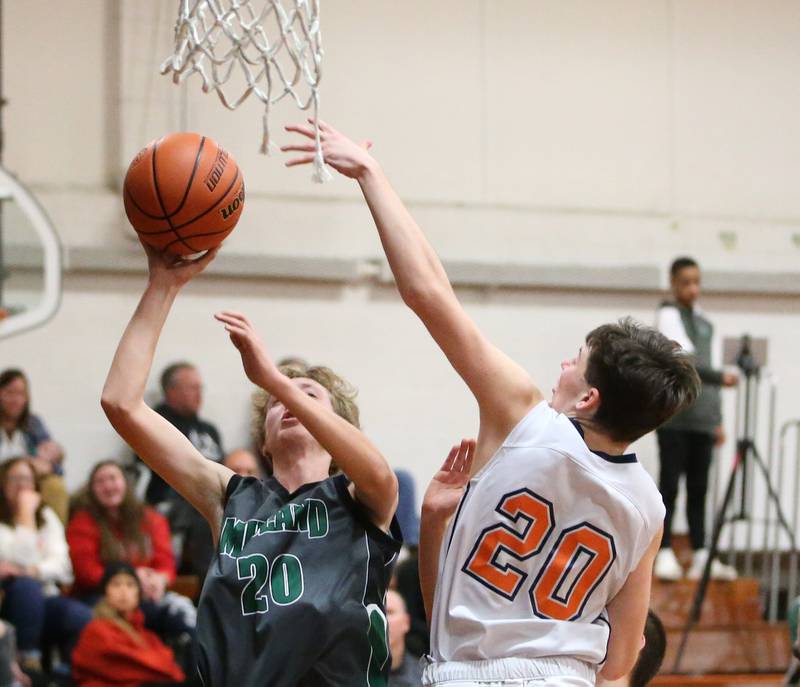 Midland's Jacob Spicer (left) runs in the lane to score on a layup as DePue's Vance Hayes (right) defends on Monday, Dec. 19, 2022 at DePue High School.