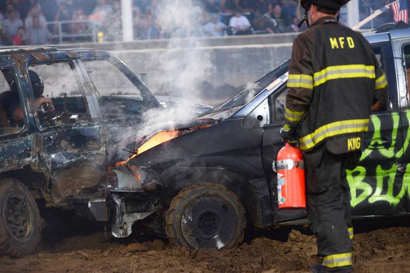 A Morrison firefighter douses a fire under the hood of one of the vehicles competing in the mini van/SUV heat at the Whiteside County Fair's demolition derby on Saturday, Aug. 17, 2024.