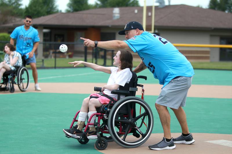 Kane County Cougars hitting coach Matt Passerelle watches as Marklund client Kristen J. throws the ball during a softball game at Marklund Hyde Center in Geneva on Tuesday, July 9, 2024.