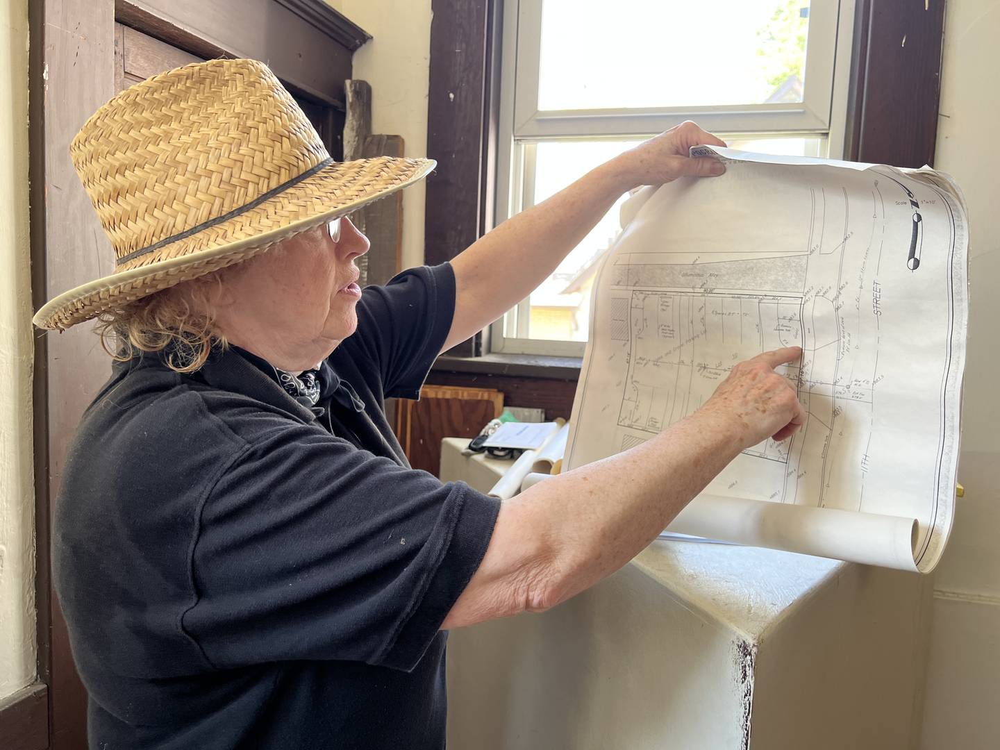 On Aug. 24, 2022, Anna Marie Coveny looks at a blueprint recovered from the DeKalb Area Women's Center basement after it was flooded in early August.