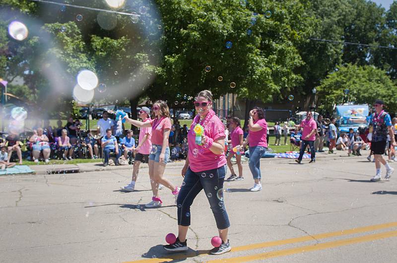 Bubbles fill the air as ambassadors of the Petunia Fest march through Sunday’s parade.