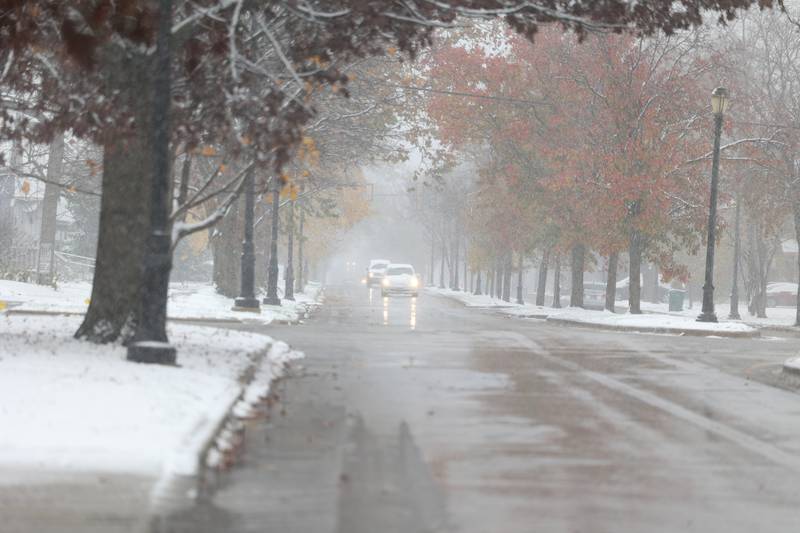 Snow falls as traffic moves along South Raynor Avenue in Joliet on Thursday, Nov. 21, 2024.