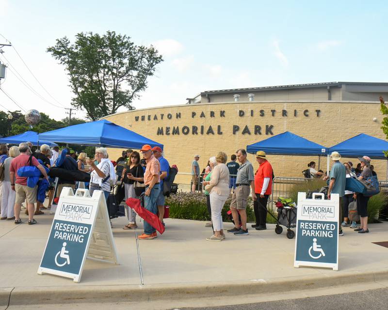 Rolling Stones fans make their way into the entrance of Memorial Park in Wheaton for the Rocks Off: A Tribute to The Rolling Stones tribe band on Friday Aug. 2, 2024.
