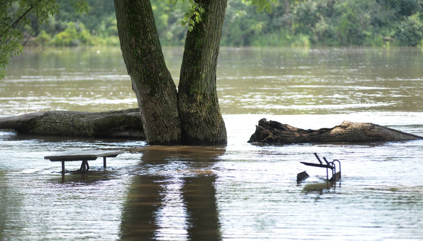 A picnic table and grill are almost submerged in floodwaters as Rock River levels continued to rise at Castle Rock State Park, south of Oregon, on Monday, July 15, 2024.
