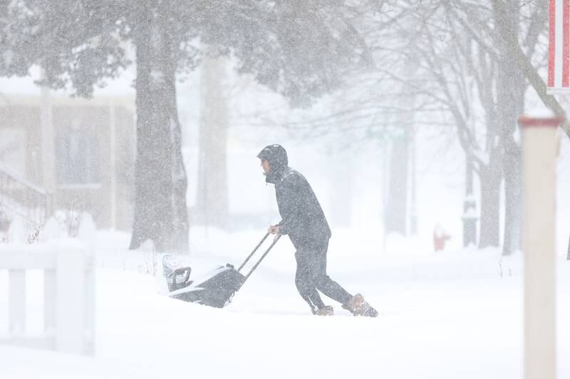 Daniel Hernandez snow blows his driveway along North Raynor Avenue. Wednesday, Feb. 2, 2022 in Joliet.