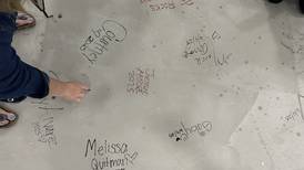 Staff at Joliet’s Gompers Jr. High leave mark on new gym floor