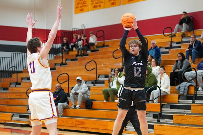 Oswego East's Lukas Adolfs (12) shoots a three pointer against Downers Grove North's Jack Crowley (11) during a Batavia Night of Hoops Basketball game at Batavia High School on Saturday, Jan. 25, 2025.