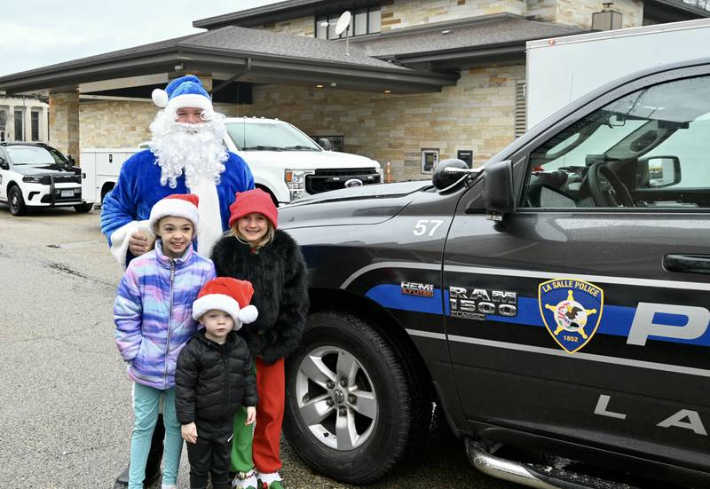 Officer Santa stands with Olivia Blair,7, Jerra Martin,8, and Ky Picha,2, on Saturday, Dec. 16 before delivering presents as a part of La Salle's Christmas program.