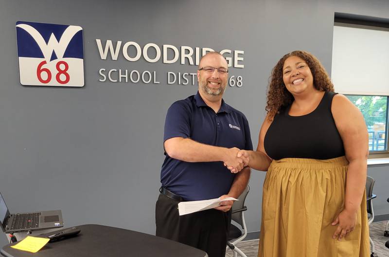 Woodridge 68 School Board President Steve Gustis congratulates Alisa Zawodny after Board approval and contract signing July 25 2022