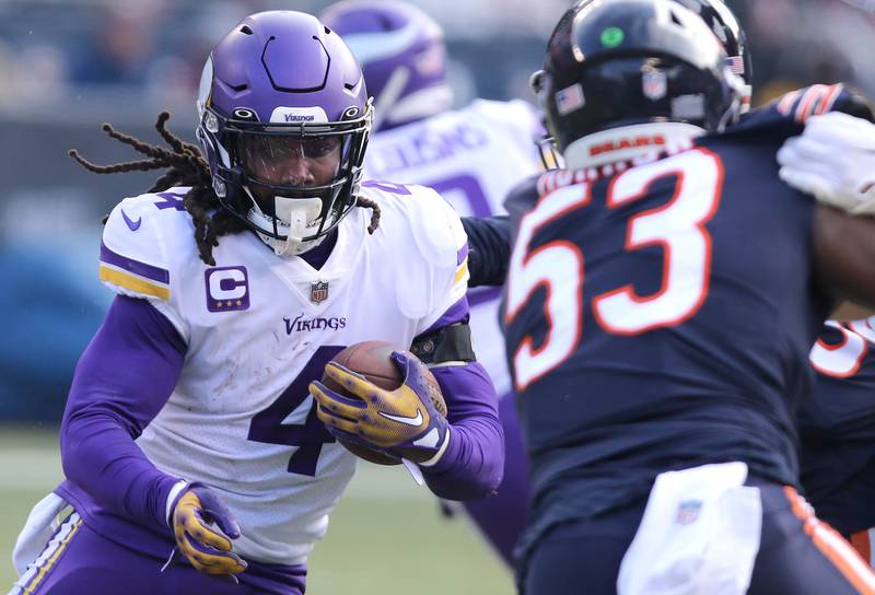 Minnesota Vikings running back Dalvin Cook follows blocking past Chicago Bears linebacker Nicholas Morrow Sunday, Jan. 8, 2023, during their game at Soldier Field in Chicago.