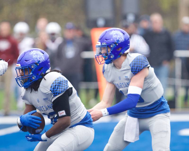 St Francis Brady Palmer hands the ball of to Tivias Caldwell against Prairie Ridge at the Class 5A second-round playoff game on Saturday Nov.9,2024 in Wheaton.