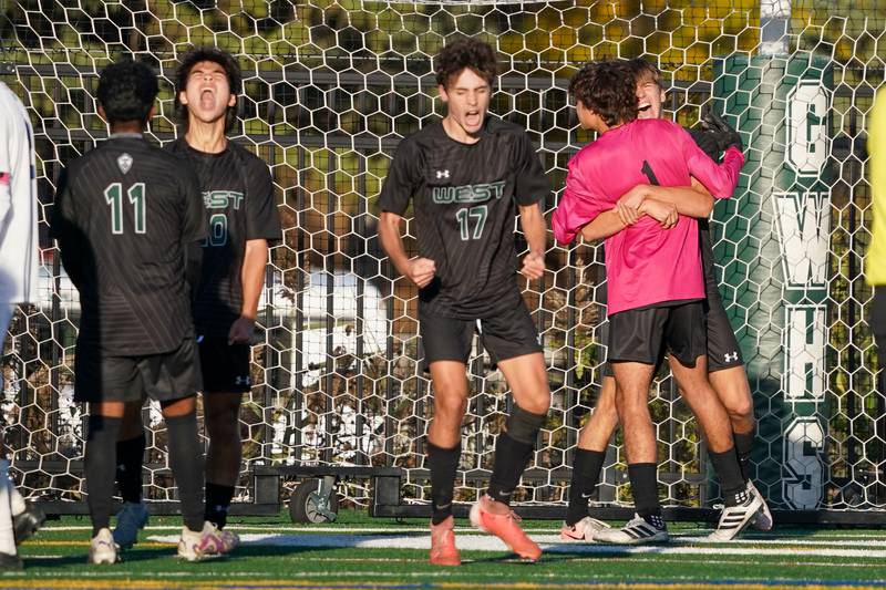 Glenbard West players celebrate after defeating St. Charles North to win the class 3A Glenbard West Regional soccer final at Glenbard West High School in Glen Ellyn on Saturday, Oct. 26, 2024.