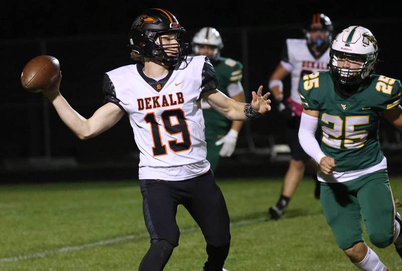 DeKalb's Michael Hodge shows a pass just ahead of the pass rush of Waubonsie Valley’s Will Tracy during their game Friday, Oct. 11, 2024, at Waubonsie Valley High School in Aurora.