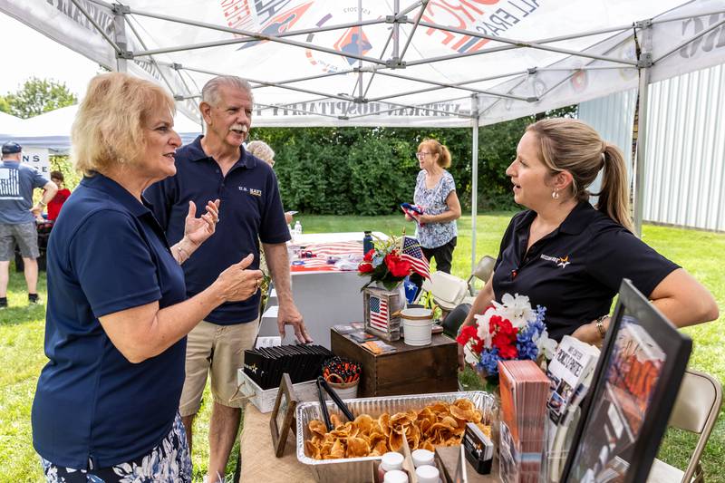 Navy veterans Sherri and Dale Jones chat with Laura Mahler of Mission BBQ during AllenForce's grand opening event which introduced the community to the new Veteran Wellness & Recreation Center in Joliet on July 25, 2025.