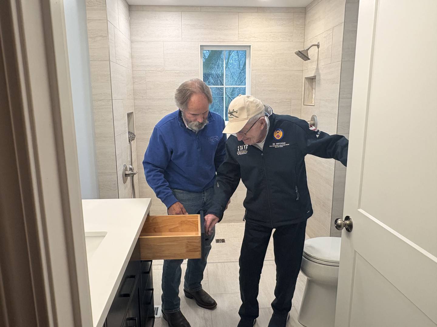 World War II veteran Ed Berthold, right, looks at his newly renovated bathroom that was made to be more accessible.