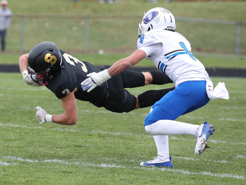 Sycamore's Carter York dives for extra yards in front of St. Francis' Asher Boose Saturday, Nov. 16, 2024, during their Class 5A quarterfinal game at Sycamore High School.