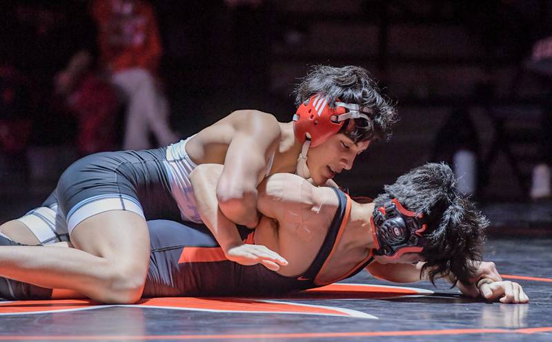 Marian Central's Andrew Alvarado and St. Charles East's Payton Lee wrestle at 132 pounds during a match in St. Charles on Wednesday, December 20, 2023.