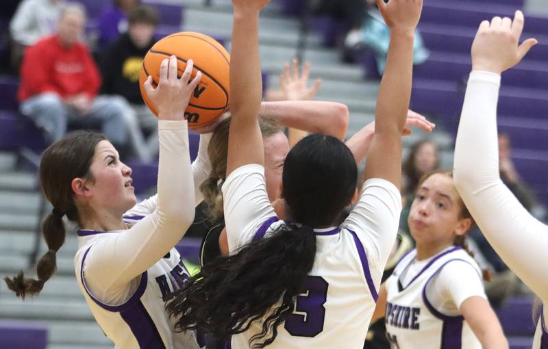 Hampshire’s Roni Dumoulin, left, tussles with others for the ball against Sycamore in varsity girls basketball on Friday, Jan. 3, 2025, at Hampshire High School in Hampshire.