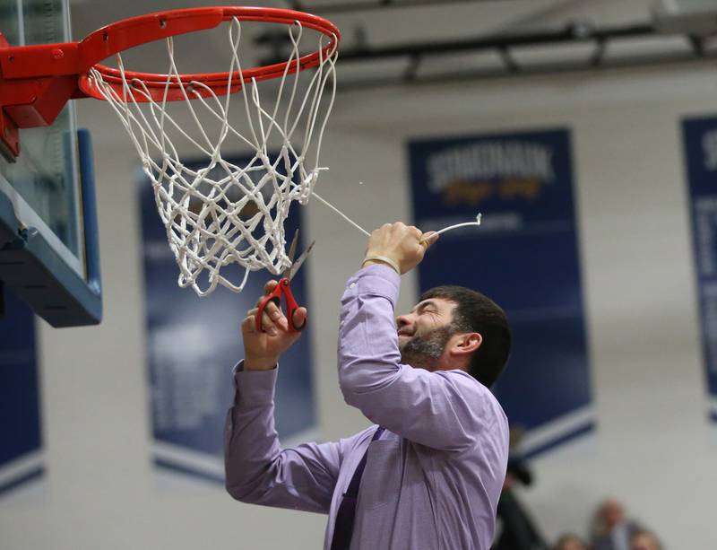 Serena head boys basketball coach Dan Twait cuts down a piece of the net after winning the Little Ten Conference Championship over Earlville on Friday, Feb. 2, 2024 at Somonauk High School.