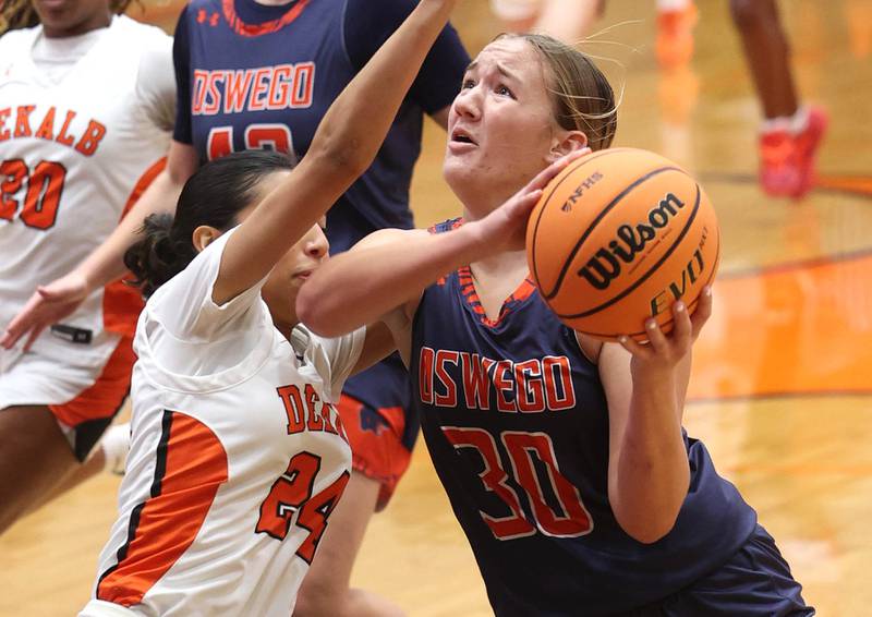 Oswego's Peyton Johnson goes to the basket against DeKalb's Nazeria Dean during their game Monday, Jan. 5, 2026, at DeKalb High School.