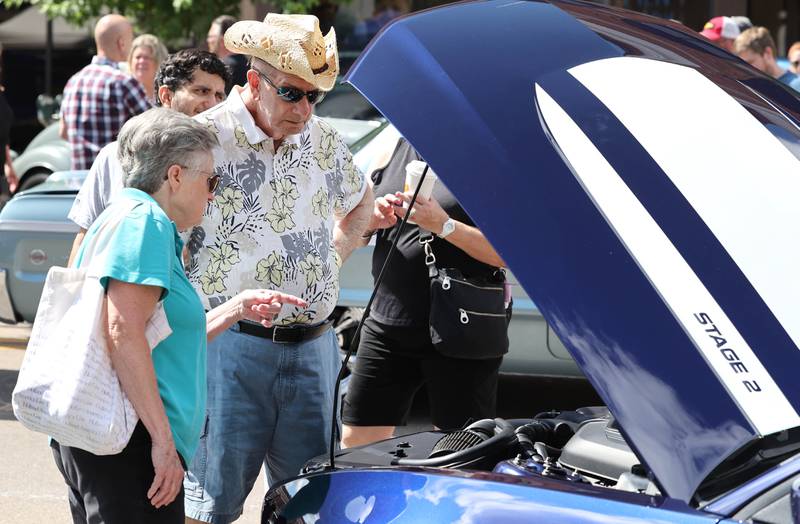 Gary Moberg and his wife Cheryl, from Sycamore, check out one of the cars at the Fizz Ehrler Memorial Turning Back Time Car Show Sunday, July 30, 2023, in downtown Sycamore.
