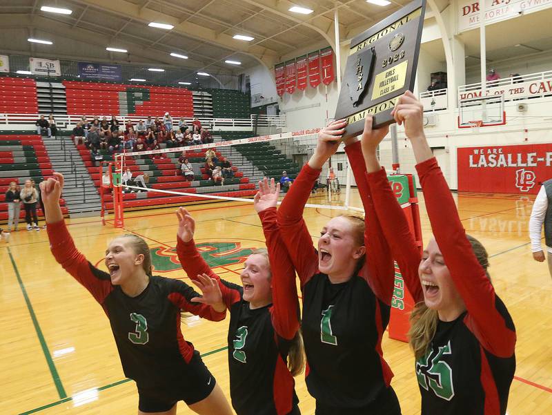 Members of the L-P volleyball team (from left) Kaylee Abens, Bridget Hoskins, Addison Duttlinger and Addison Urbanski hoist the Class 3A Regional plaque after defeating Morris on Thursday, Oct. 26, 2023 at Sellett Gymnasium.