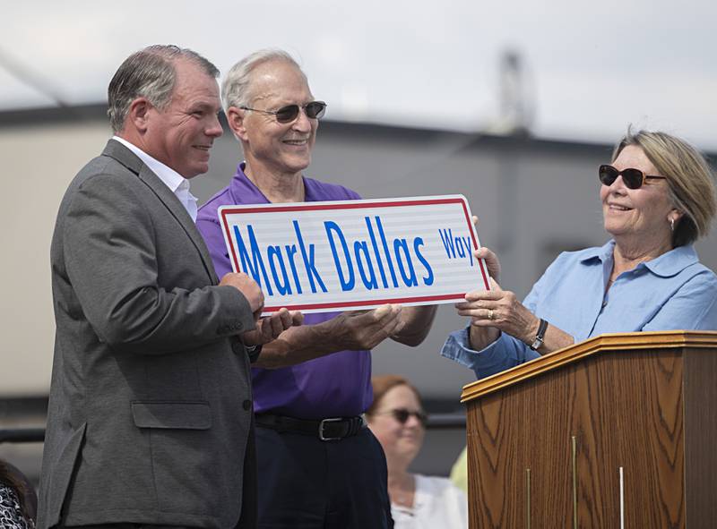 Mark Dallas (left) accepts a replica sign from Dixon Mayor Glen Hughes and Board of Education President Linda Wegner Tuesday, May 30, 2023.