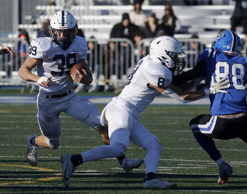 Cary-Grove's Holden Boone runs with the ball behind the block of his teammate,Andrew Prio, during a IHSA Class 6A semifinal playoff football game against Lake Zurich on Saturday, Nov. 18, 2023, at Lake Zurich High School.