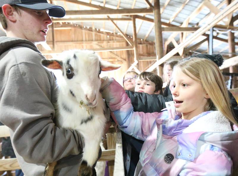 Josie Buckman, a student at Bureau Valley, pets a dairy goat during the 29th annual Ag Fair on Thursday, March 20, 2025 at the Bureau County Fairgounds in Princeton. This year, approximately 325 students from Princeton, La Moille, Depue and Bureau Valley schools attended the fair. The Ag. Fair featrued 14 different learning centers. Stations ranged from dairy, embroyology, safety, pork, corn, seed science, conservation, beef soybeans, pollination, technology, equipment and animals. The fair was started by the Farm Bureau Women's Committie and the Bureau County Ag Coalition Committee.
