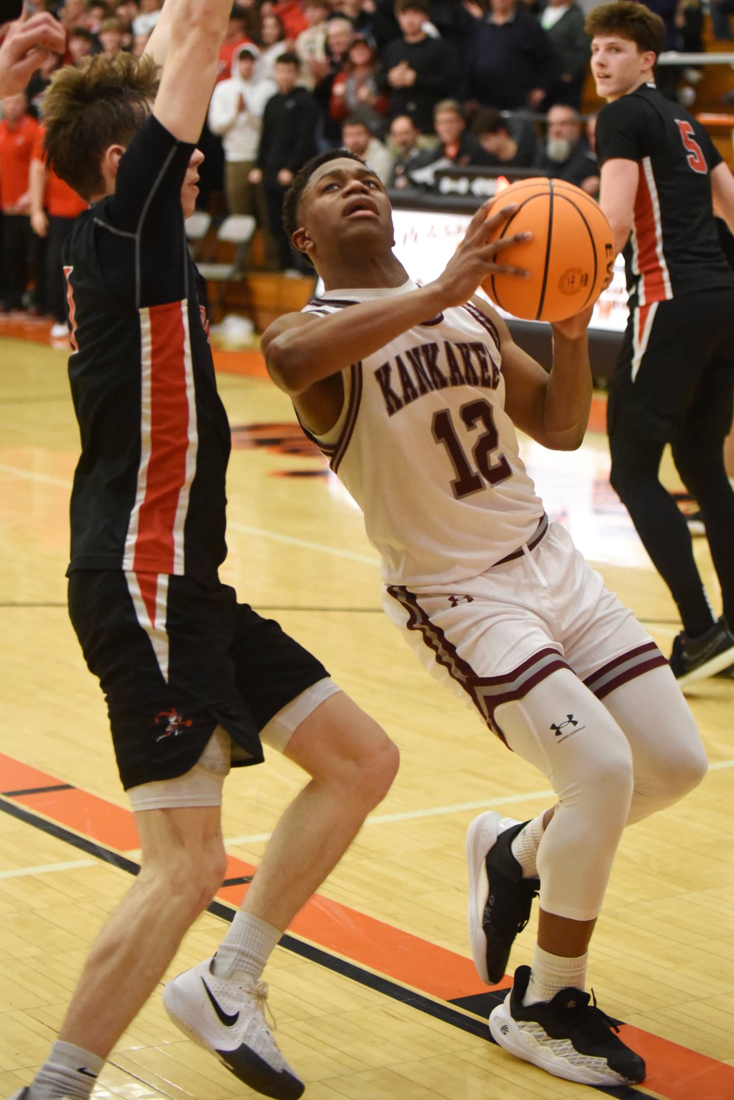 Kankakee's Myair Thompson, right, looks for a shot over Metamora's Ashton Grieves during the IHSA Class 3A Washington Sectional semifinals Tuesday, March 4, 2025.