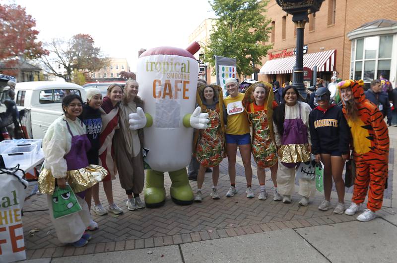Woodstock High School cross country runners stop to pose for a picture and trick or treat during a run at  Halloween on the Square on Thursday, Oct. 31, 2024, in Woodstock.