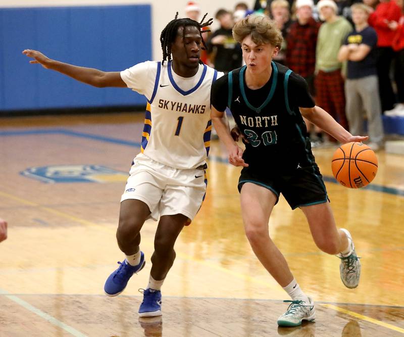 Woodstock North's Ethan Richardson (right) tries to drive to the basket against Johnsburg's Jarrel Albea during a Kishwaukee River Conference boys basketball game on Monday, Dec. 15, 2025, at Johnsburg High School.