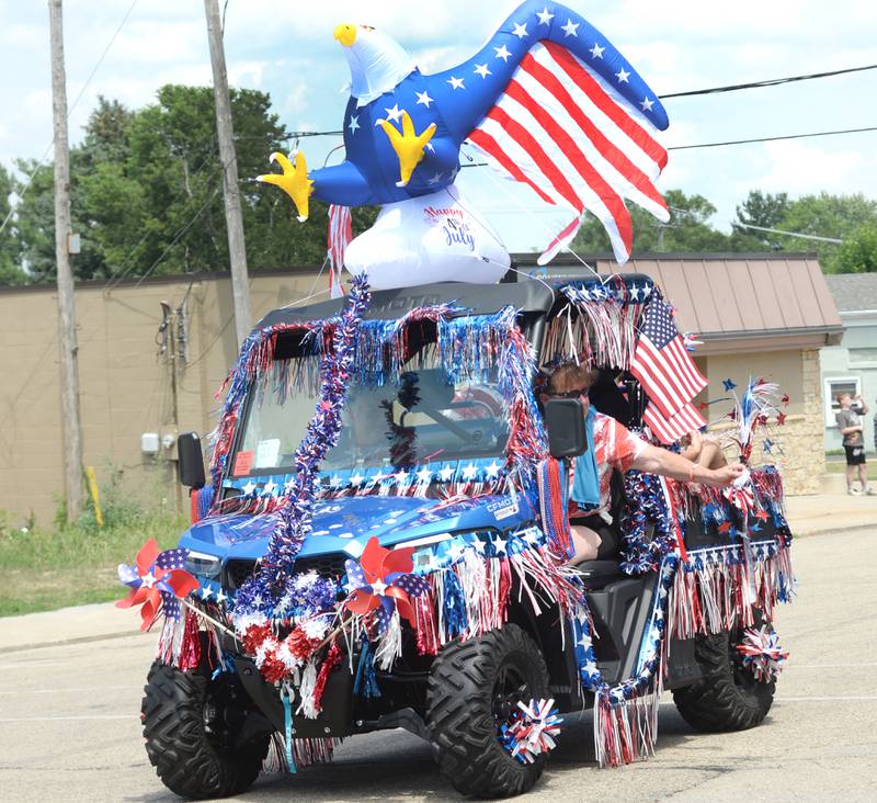 Theresa Gabrielson tosses candy to the crowd in her decorated golf cart entry "Just for Fun" during the Let Freedom Ring parade on Friday, July 4, 2025 in Mt. Morris. The entry won the "Best Patriotic Entry".