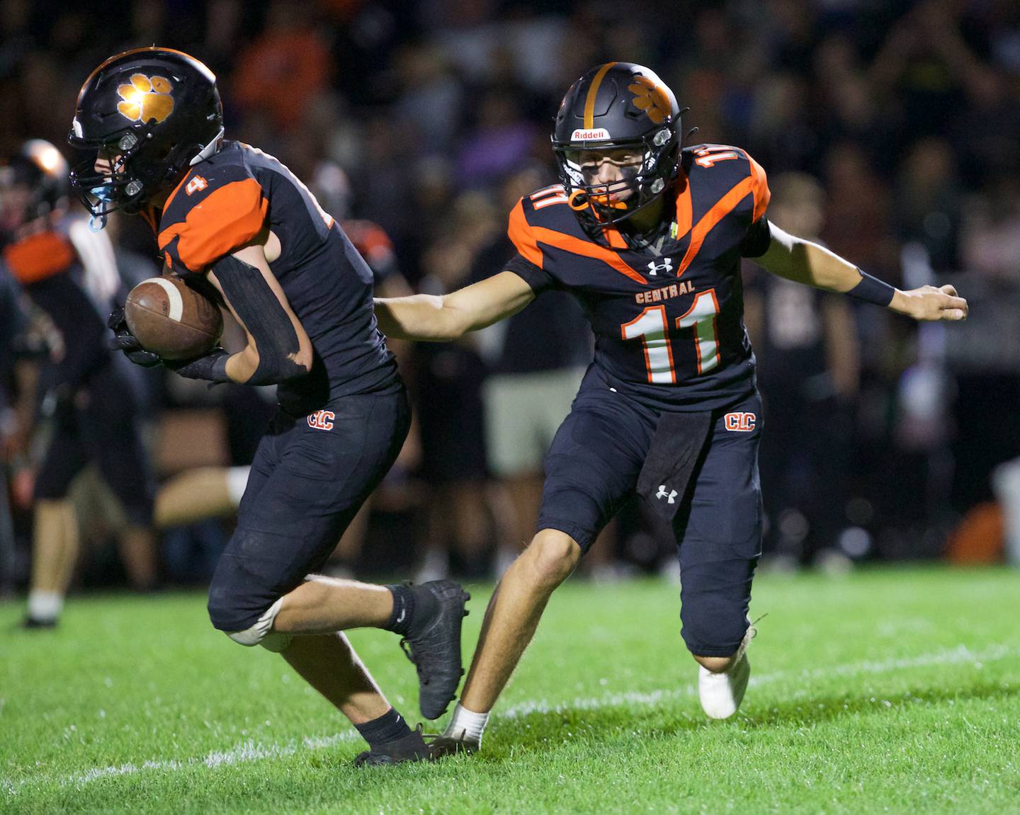 Crystal Lake Central's Brett Kramer hands the ball off to Carter Kelley against Crystal Lake South on Friday, Sept. 27,2024 in Crystal Lake.