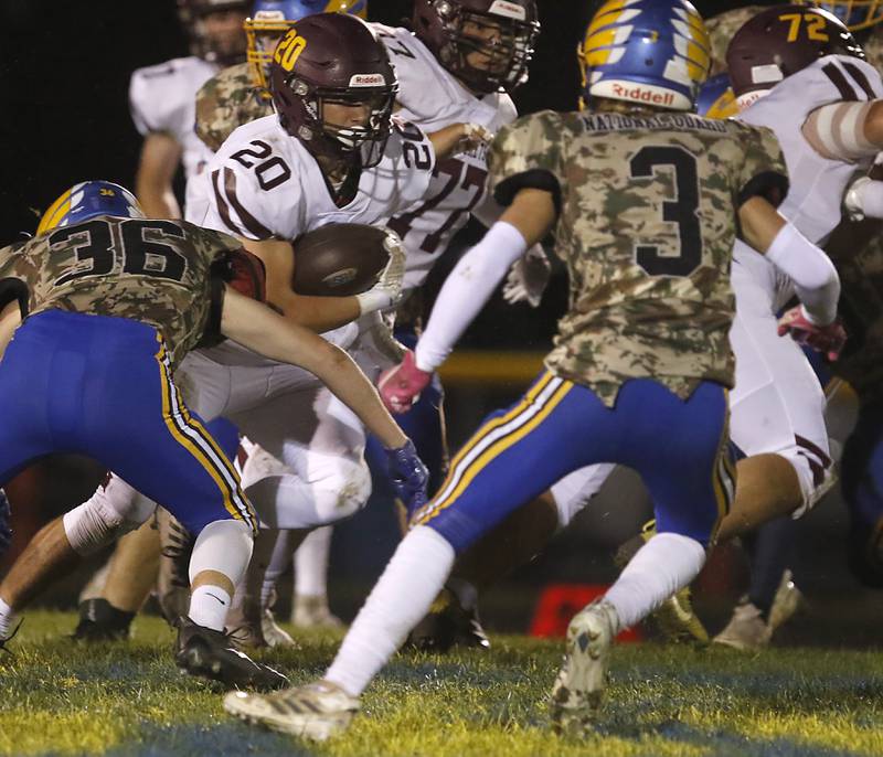 Richmond-Burton's Luke Johnson looks to run between Johnsburg's Deegan Turner and  Maddux Malachuk during a Kishwaukee River Conference football game on Friday, Oct.6, 2023, at Johnsburg High School.