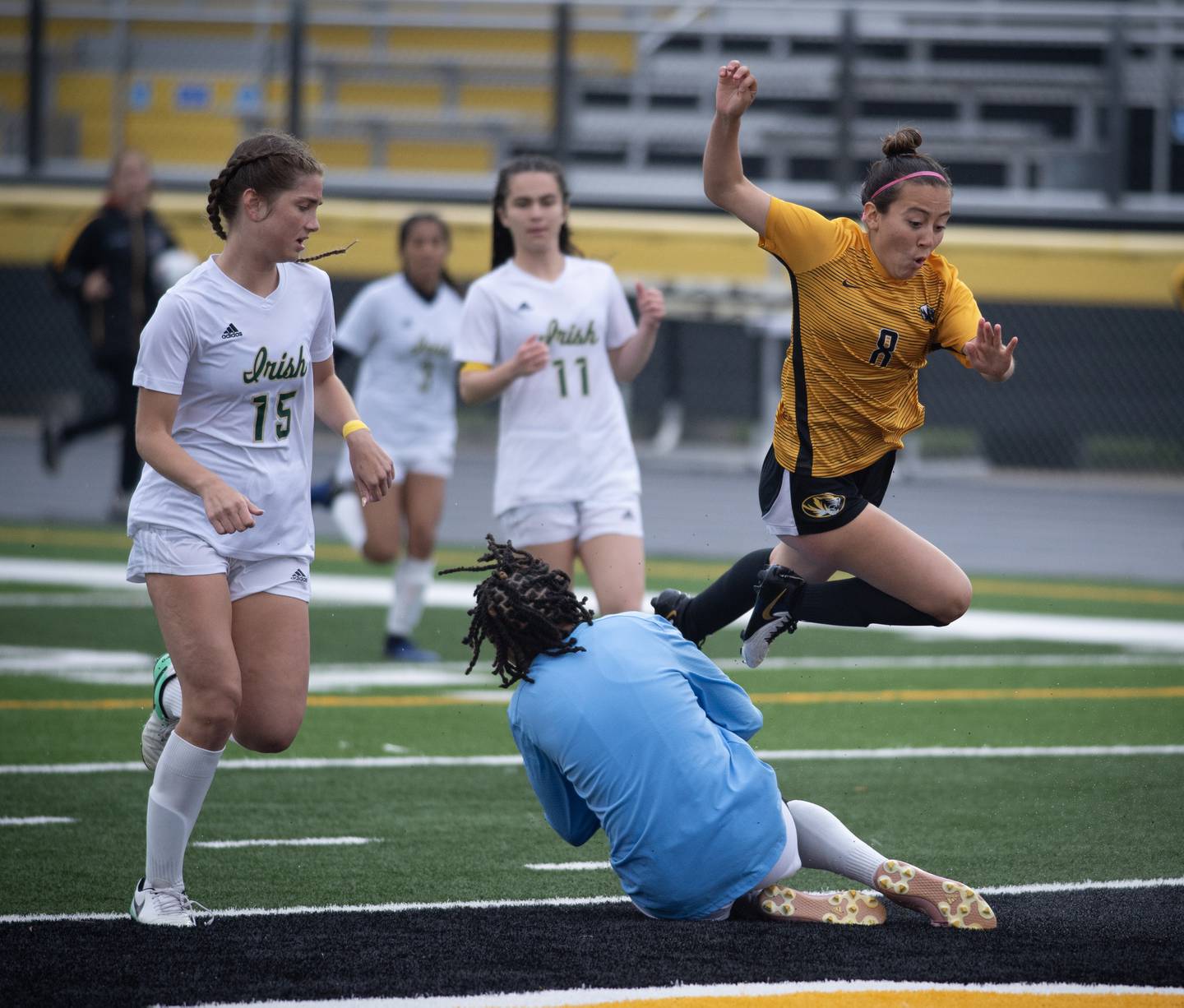 Herscher's Gianni Jaime leaps out of the way while trying to get a shot on goal as Bishop McNamara's Kaneyce Davis comes out to make a save during a regional championship game on Tuesday, May 20, 2025.