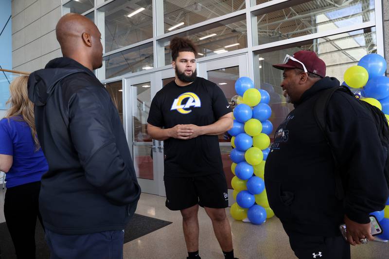 Keagen Trost, a 2019 Kankakee High School grad, talks to his former coaches, Omar Grant, left, and J.J. Hollis during a celebration held for him at the school on May 4, 2026, following him being drafted into the NFL to the Los Angeles Rams.