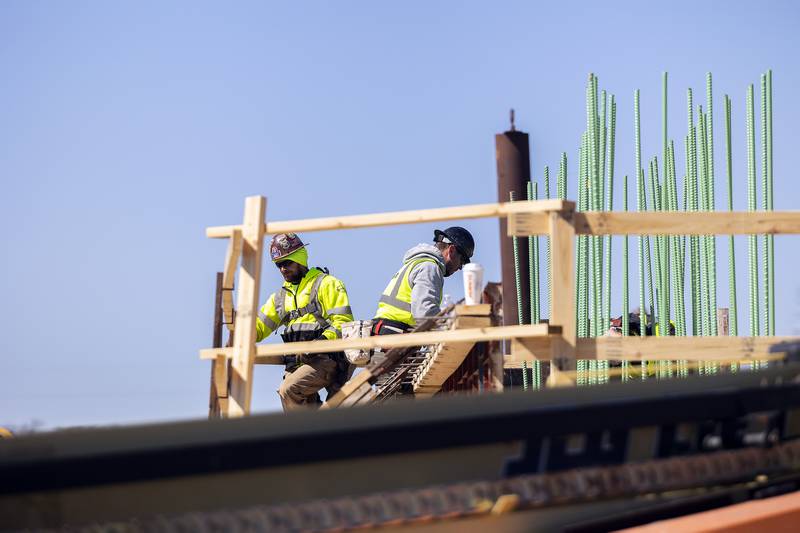 Workers are extending old railroad piers up for the building of the Project Rock pedestrian bridge Tuesday, April 8, 2025, in Dixon.