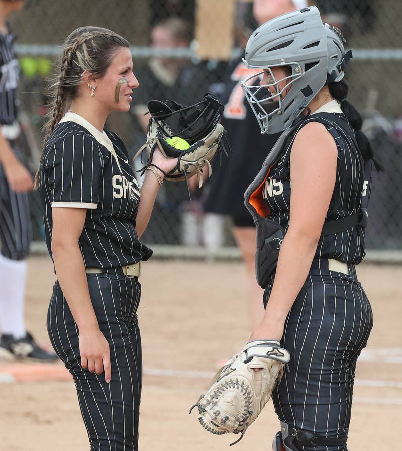 Sycamore catcher Kairi Lantz goes out to talk to pitcher Sycamore's Bella Jacobs Tuesday, June 3, 2025 during their Class 3A sectional semifinal game against Crystal Lake Central at Sycamore High School.