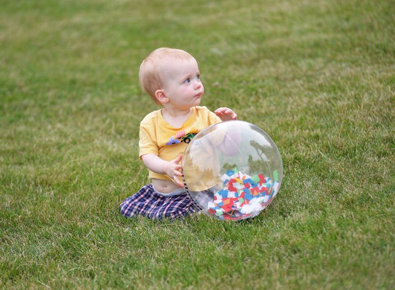 Elsie Todd, 14 months, of Oregon, plays with one of the plastic balls given away by Stillman Bank during the Oregon Park District's Concert in the Park on Tuesday, June 17, 2025 at Oregon Park West.  Stillman sponsored the band "That Gurl" in what was the opening week of the free concerts.